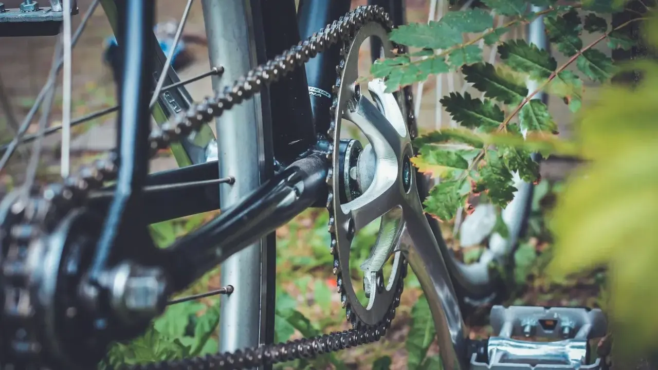 Zbliżenie na mechanizm korbowy i łańcuch rowerowy. Różne rodzaje łańcuchów rowerowych zapewniają płynną jazdę.