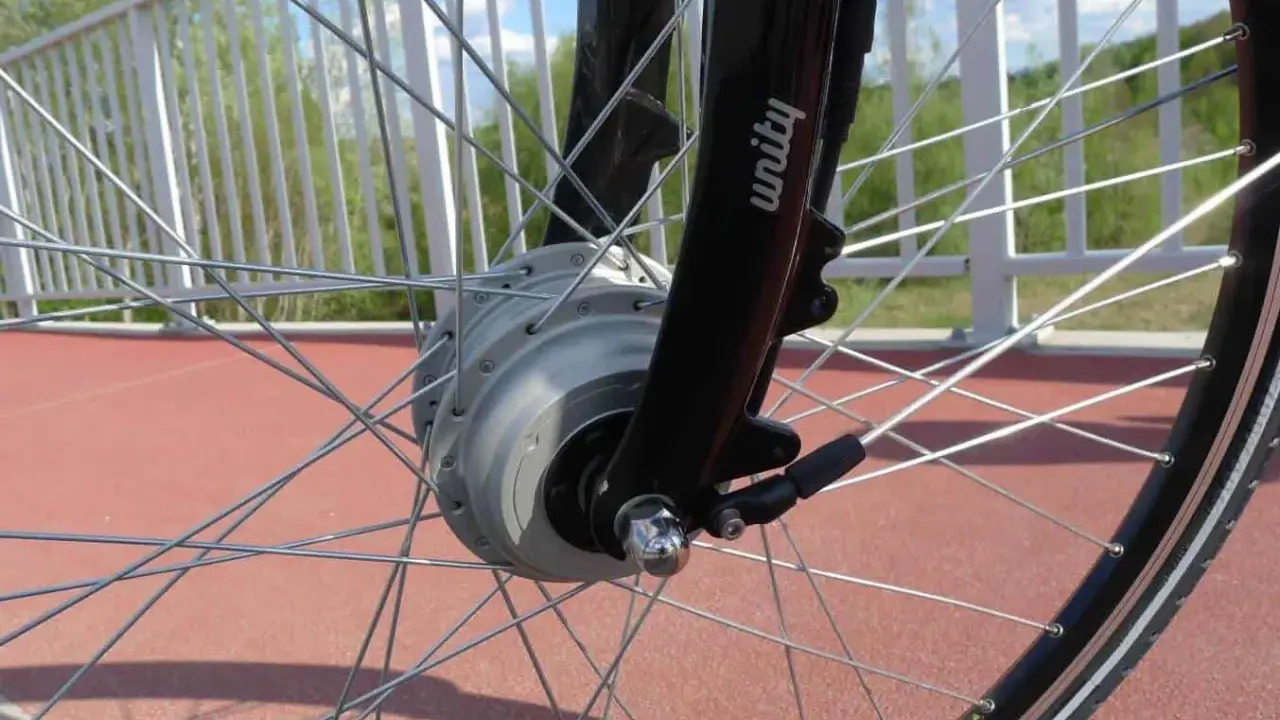Szprychowe koło roweru elektrycznego z widocznym silnikiem w piaście. Czy na rower elektryczny trzeba mieć prawo jazdy? Sprawdź przepisy!