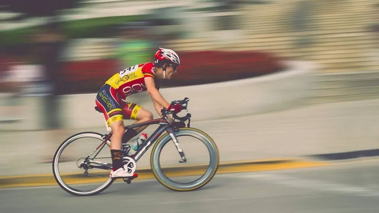 Kolarz w żółto-czerwonym stroju pędzi na rowerze podczas maratonu rowerowego.