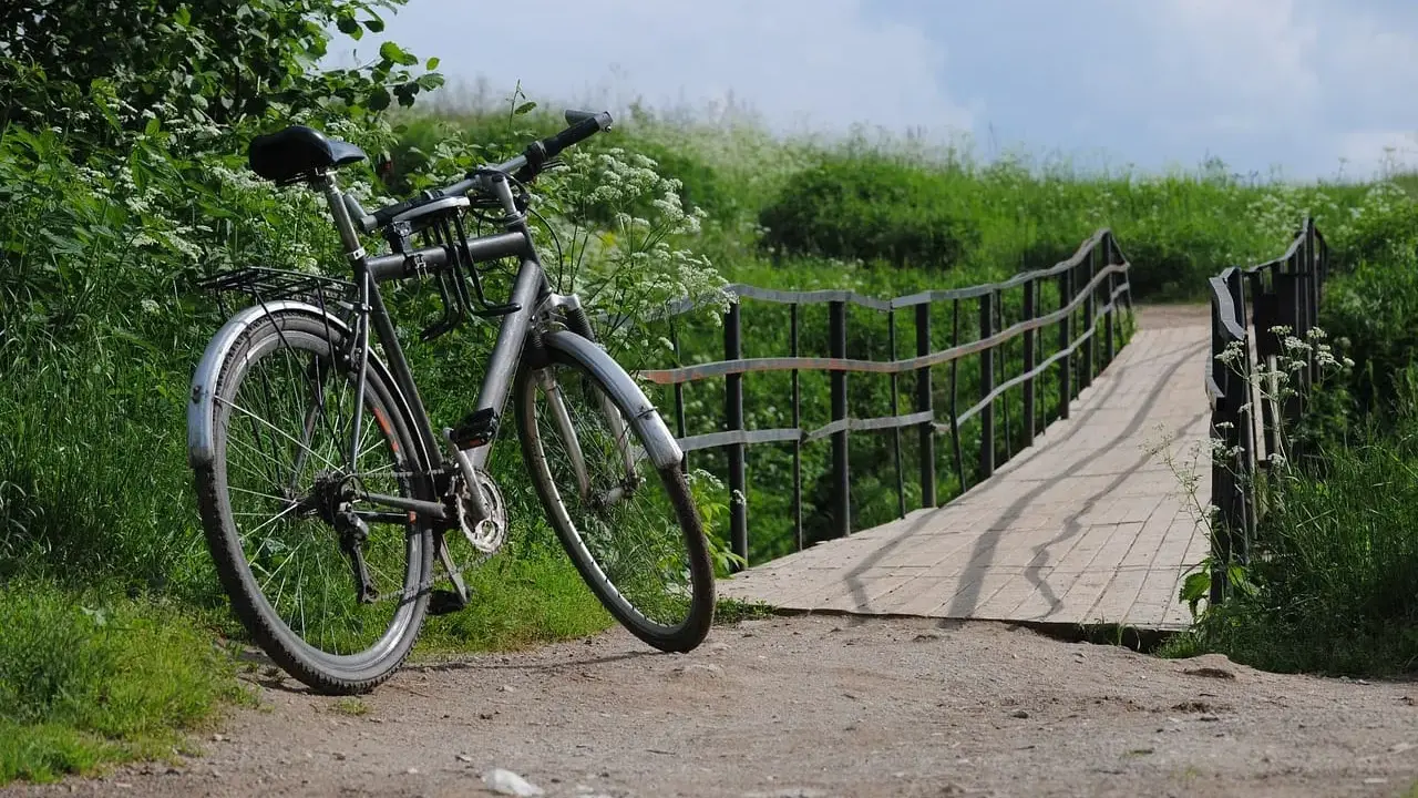 Rower czeka przy moście, gotowy na dalszą podróż. Idealne miejsce na noclegi dla rowerzystów, gdzie można odpocząć po dniu pełnym wrażeń.