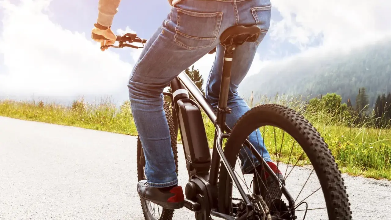 Osoba na rowerze elektrycznym cieszy się jazdą po malowniczej trasie. Dofinansowanie do roweru sprawia, że takie wycieczki są dostępne dla każdego.