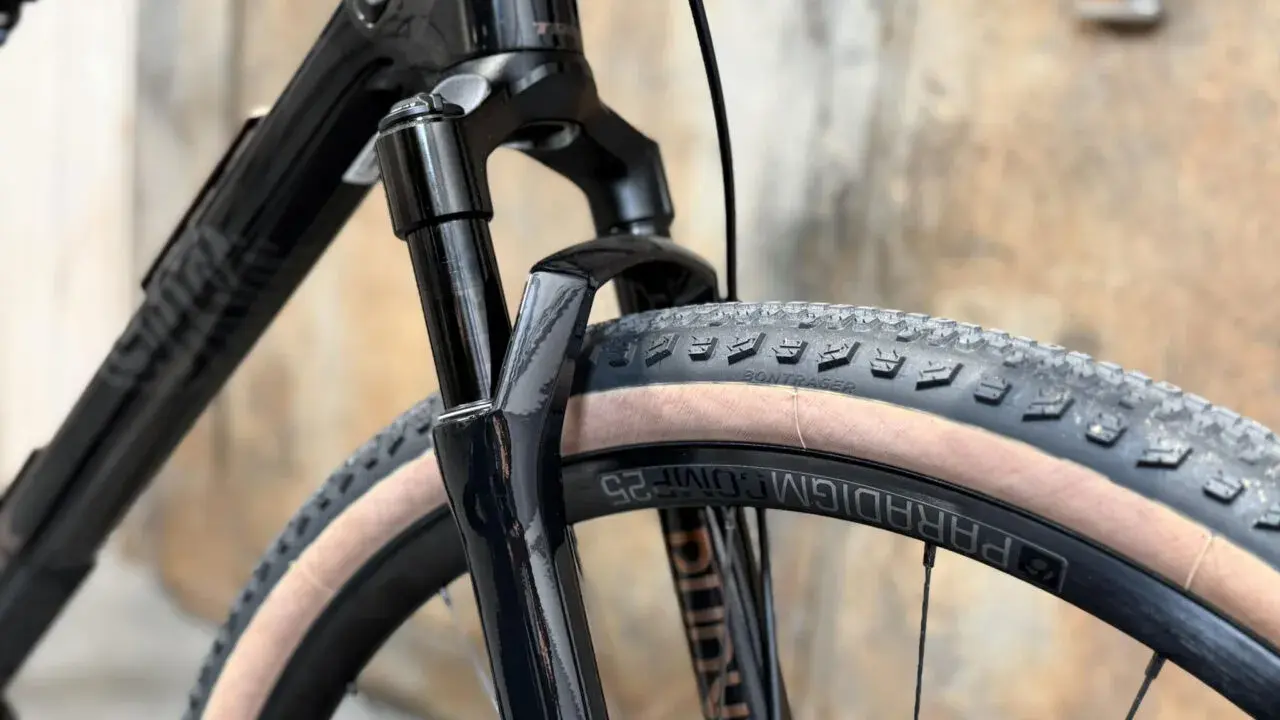 Czarny rower gravelowy marki Trek, z widocznym amortyzatorem i oponą Bontrager. To świetny wybór dla miłośników przygód.