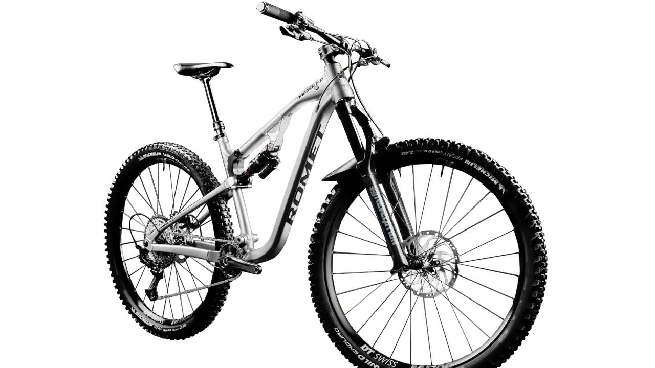 Srebrny rower górski, idealny na trudne trasy. Czy to rower crossowy czy mtb? Zdecydowanie ten drugi, gotowy na każde wyzwanie.