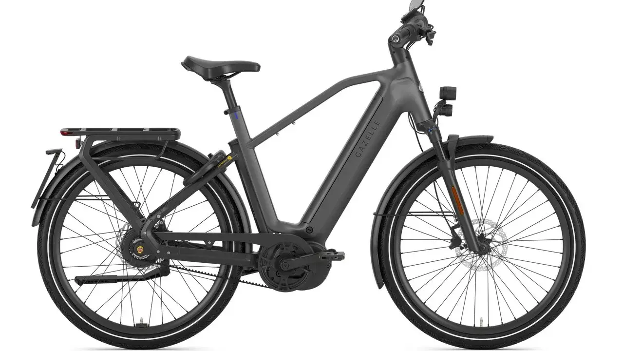 Szary rower elektryczny Gazelle z bagażnikiem i oświetleniem, jeden z najszybszych rowerów elektrycznych na rynku.