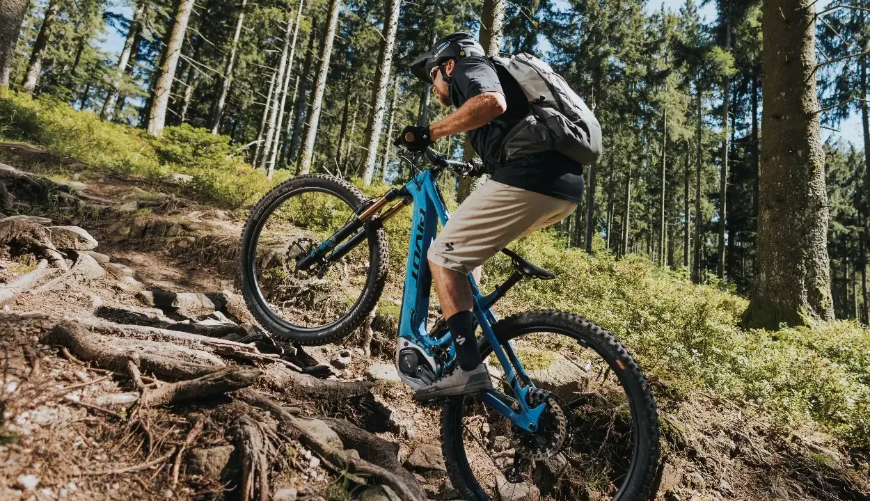 Kolarz na rowerze elektrycznym z napędem Bosch Performance Line CX pokonuje kamienisty, leśny szlak.
