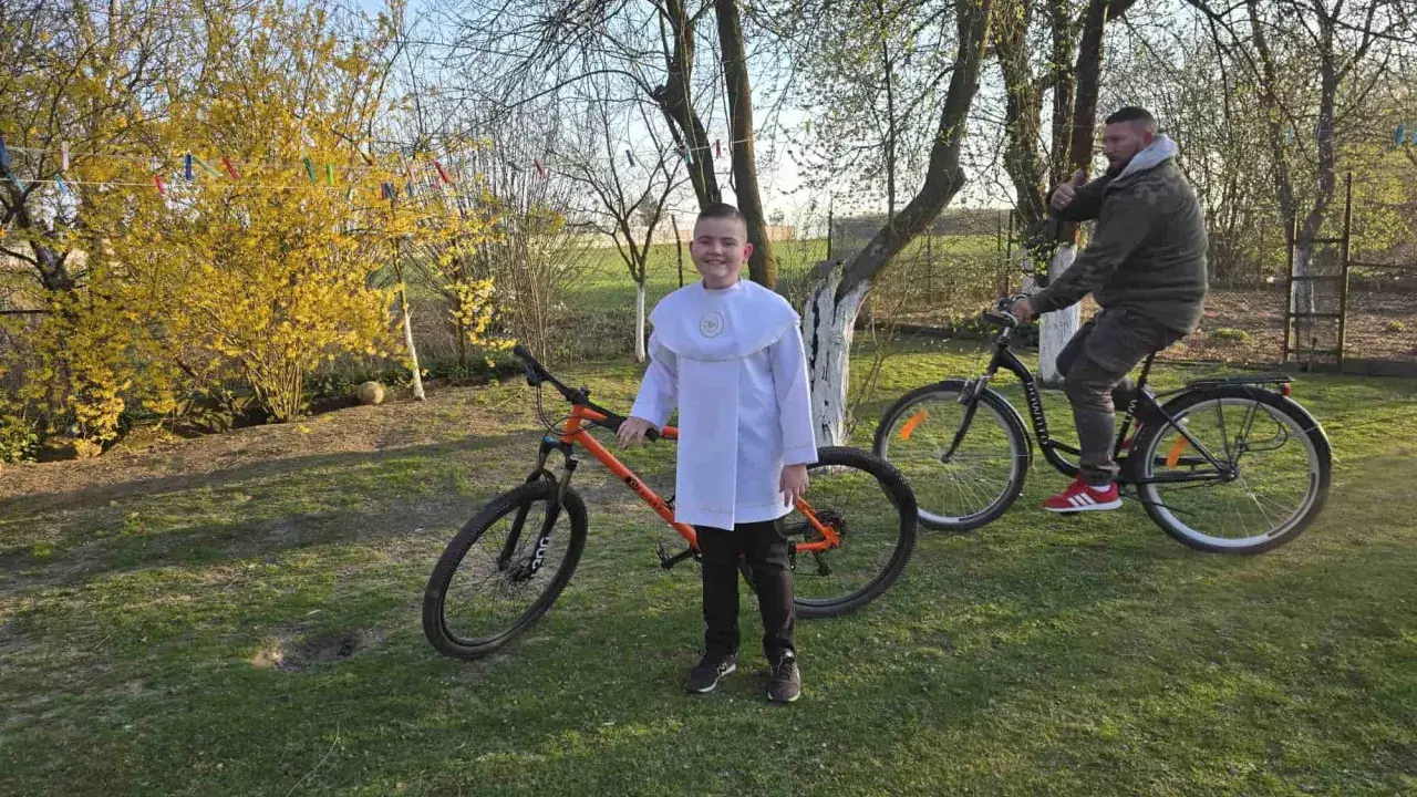 Chłopiec w albie i mężczyzna na rowerach. Pomarańczowy rower 29 cali na jaki wzrost?