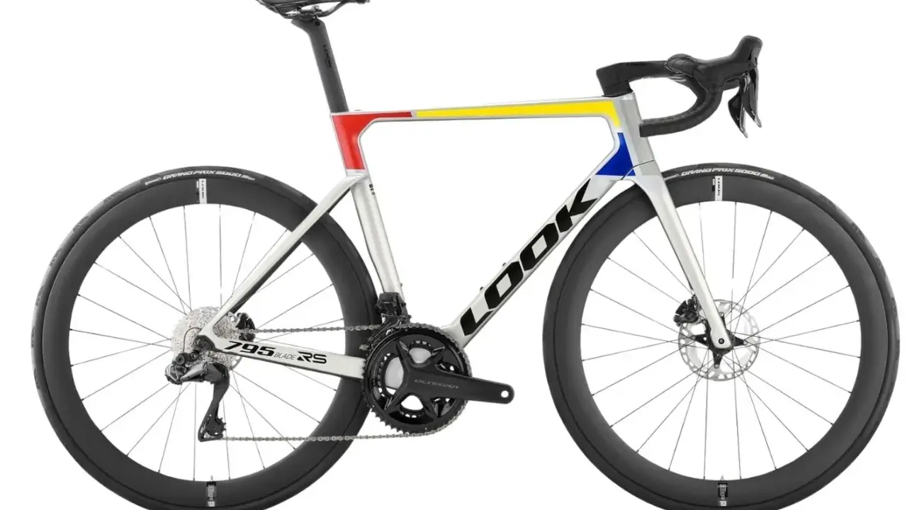 Srebrny rower szosowy LOOK 795 Blade RS z kolorowymi akcentami: czerwonym, żółtym i niebieskim.