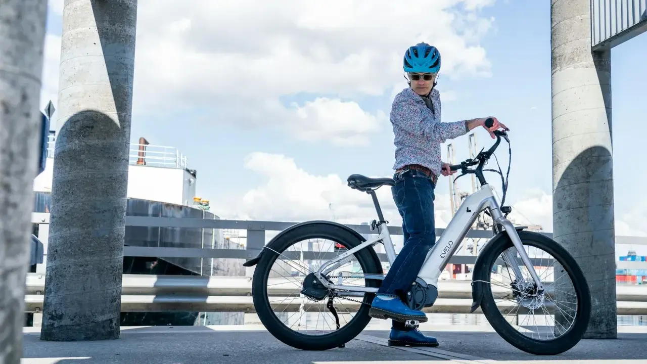Mężczyzna w kasku na rowerze elektrycznym. Zastanawiasz się, ile wytrzymuje bateria w rowerze elektrycznym? Ten model oferuje długi zasięg.
