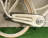Jak dobrać osłonę łańcucha rowerowego? Zobacz, jak wygląda osłona na kremowym rowerze, chroniąca łańcuch i zębatkę.