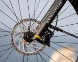 Szprychy koła rowerowego, tarcza hamulcowa i amortyzator SR Suntour. Dowiedz się, jak pompować wentyl Schrader.