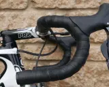Czarna, wzorzysta owijka na kierownicę roweru szosowego z czarnymi manetkami Shimano.