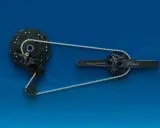 Zestaw napędowy **Shimano CUES**: przerzutka tylna, kaseta i korba z zębatkami, połączone łańcuchem na niebieskim tle.
