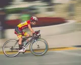 Kolarz w żółto-czerwonym stroju pędzi na rowerze podczas maratonu rowerowego.