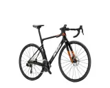 Czarny rower szosowy KTM Revelator Alto z pomarańczowymi akcentami, gotowy na podbój szos.
