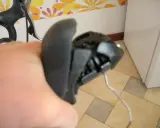 Wymiana linki przerzutki w manetce obrotowej. Widoczna ręka trzymająca manetkę, z której wystaje linka.