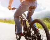 Osoba na rowerze elektrycznym cieszy się jazdą po malowniczej trasie. Dofinansowanie do roweru sprawia, że takie wycieczki są dostępne dla każdego.