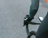 Rowerzysta w rękawiczkach z logo, trzymający kierownicę szosową. Kluczowe jest, jak dobrać szerokość kierownicy szosowej dla komfortu.