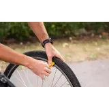 Rowerzysta wymienia oponę. Zastanawiasz się, gdzie wyrzucić opony rowerowe? Sprawdź lokalne punkty zbiórki odpadów.