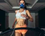 Kobieta w masce tlenowej biegnie na bieżni, badając swoje VO2max.