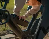Dłoń wyjmuje baterię z ramy roweru elektrycznego, pokazując, jak ładować rower elektryczny.