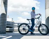 Mężczyzna w kasku na rowerze elektrycznym. Zastanawiasz się, ile wytrzymuje bateria w rowerze elektrycznym? Ten model oferuje długi zasięg.