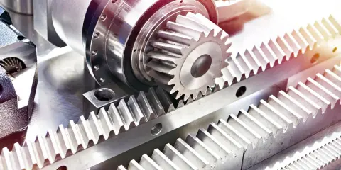 Metalowe tryby i zębatki, tworzące mechanizm przekładni zębatej, gotowe do pracy.