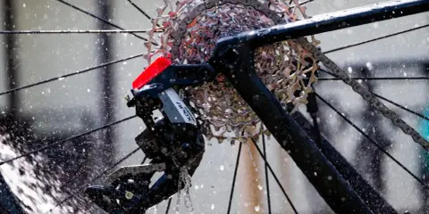 Błyszczące, elektryczne przerzutki SRAM Apex na rowerze, obmywane przez strumienie wody.