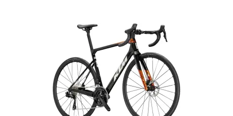 Czarny rower szosowy KTM Revelator Alto z pomarańczowymi akcentami, gotowy na podbój szos.