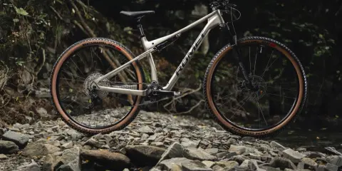 Gotowy na przygodę xc rower Romet z brązowymi oponami na kamienistym szlaku.