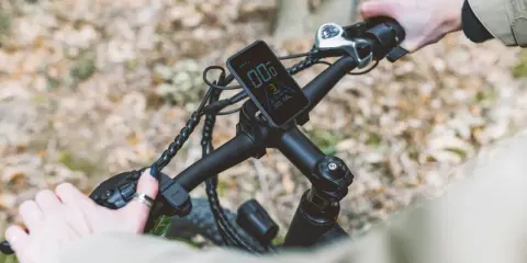 Ręce na kierownicy roweru elektrycznego, wyświetlacz pokazuje prędkość. Ant+ co to za technologia?