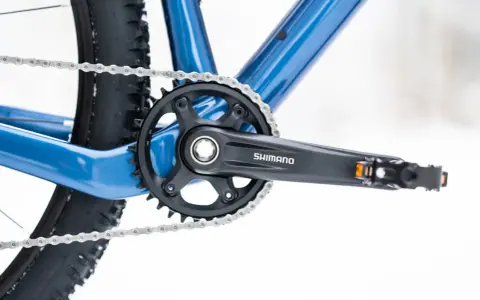 Widok na korbę rowerową Shimano i łańcuch. Dowiedz się, jak odkręcić zapieczone pedały w rowerze, gdy napotkasz takie problemy.