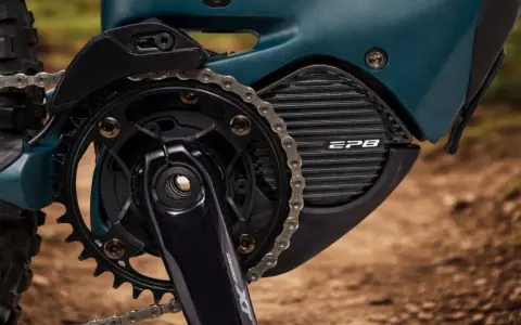 Zbliżenie na napęd roweru elektrycznego z systemem **Shimano STEPS**. Widoczna korba, zębatka, łańcuch i obudowa silnika z napisem EP8.
