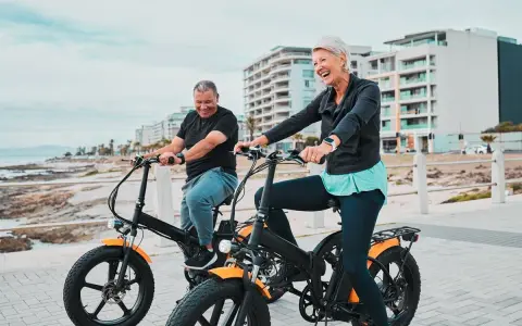 Uśmiechnięci seniorzy na rowerach hybrydowych. Jak działa taki rower? Pomaga w jeździe, dodając mocy!