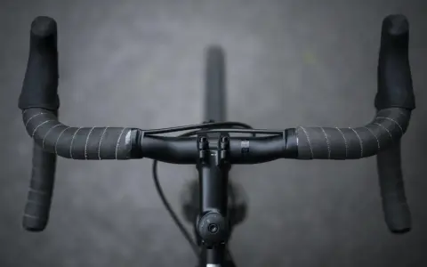 Czarne kierownica rowerowa z owijką. Widok z góry, jak odkręcić kierownicę w rowerze.