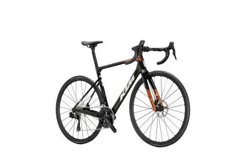 Czarny rower szosowy KTM Revelator Alto z pomarańczowymi akcentami, gotowy na podbój szos.