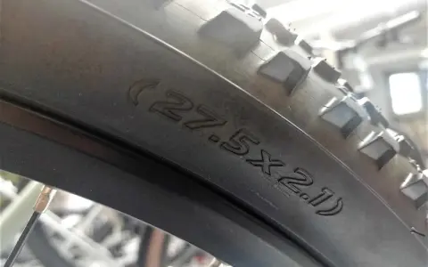 Na oponie rowerowej widoczny napis (27.5x2.1), który pomaga określić, jak zmierzyć rozmiar koła w rowerze.