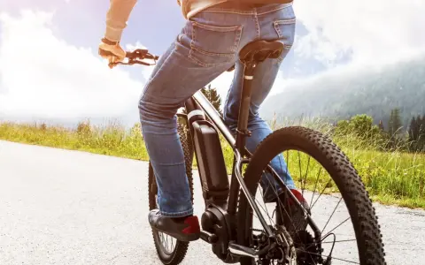 Osoba na rowerze elektrycznym cieszy się jazdą po malowniczej trasie. Dofinansowanie do roweru sprawia, że takie wycieczki są dostępne dla każdego.