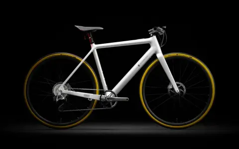 Biały rower elektryczny Eidolon z żółtymi oponami, prezentowany na czarnym tle. To najlżejszy rower elektryczny, który zachwyca minimalistycznym designem.