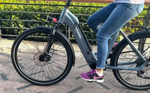 Osoba na rowerze elektrycznym Grundig, ucząc się jak jeździć rowerem elektrycznym, rusza przed siebie.