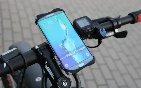 Jaki uchwyt na telefon do roweru? Samsung Galaxy S6 edge+ zamontowany na kierownicy roweru, obok licznika.