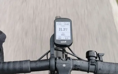 Na kierownicy roweru zamontowany jest licznik Garmin, który pokazuje dystans 7.11 km, tętno 146, rytm 102, temperaturę 6.2°C i aktualny czas 13:43. Prędkość 31.3 km/h jest widoczna na ekranie.