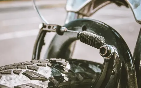 Zbliżenie na mechanizm hamulca rowerowego z widoczną sprężyną i linką. Dowiedz się, jak poluzować hamulce w rowerze.
