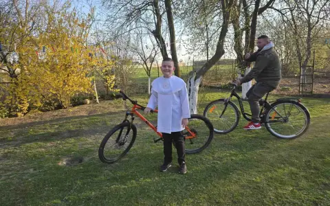 Chłopiec w albie i mężczyzna na rowerach. Pomarańczowy rower 29 cali na jaki wzrost?