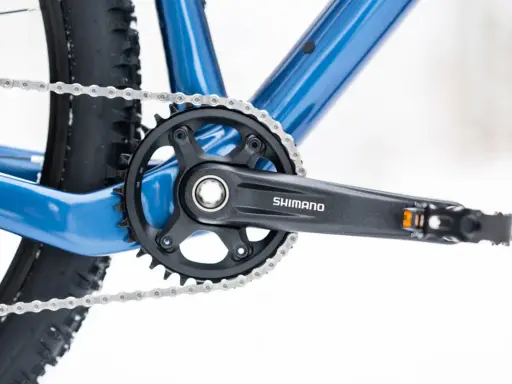 Widok na korbę rowerową Shimano i łańcuch. Dowiedz się, jak odkręcić zapieczone pedały w rowerze, gdy napotkasz takie problemy.