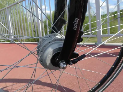 Szprychowe koło roweru elektrycznego z widocznym silnikiem w piaście. Czy na rower elektryczny trzeba mieć prawo jazdy? Sprawdź przepisy!