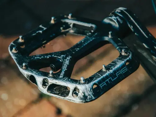 Czarne pedały Race Face Atlas, idealne jakie pedały do MTB, z widocznymi śladami użytkowania i pinami.