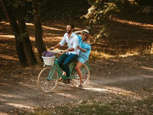 Para wzrostu 160-170 cm, rama 15 cali na rowerze z koszykiem kwiatów, na którym jedzie uśmiechnięta para.