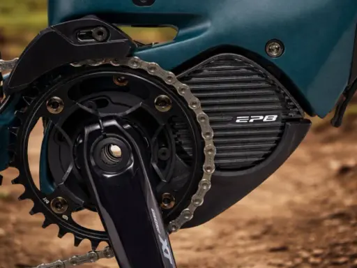Zbliżenie na napęd roweru elektrycznego z systemem **Shimano STEPS**. Widoczna korba, zębatka, łańcuch i obudowa silnika z napisem EP8.