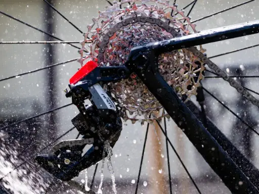 Błyszczące, elektryczne przerzutki SRAM Apex na rowerze, obmywane przez strumienie wody.