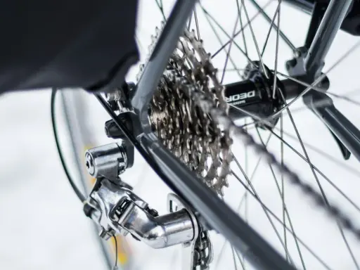 Błyszczący osprzęt Shimano Deore na tylnej przerzutce i kasecie rowerowej.